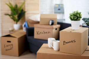 moving day - close up of brown cardboard boxes with belongings stacked in new house