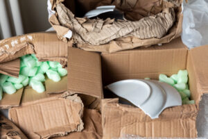 Broken dish in a damaged cardboard box after transportation