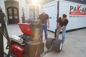 two men standing in front of a portable storage from pak-all