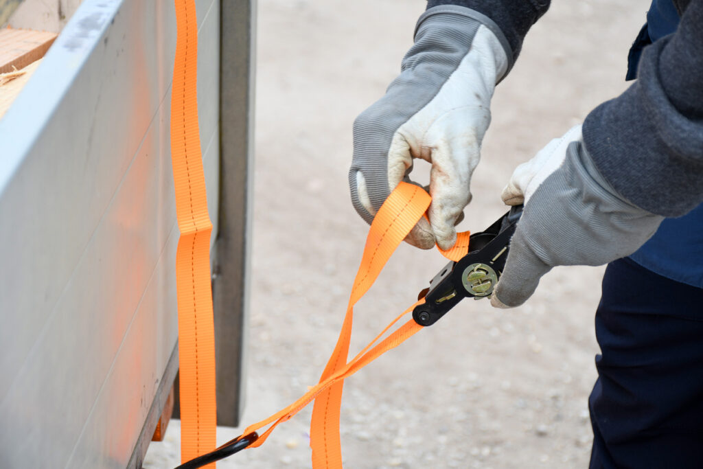 Man showing a great example of how to use a tie-down strap for moving purposes